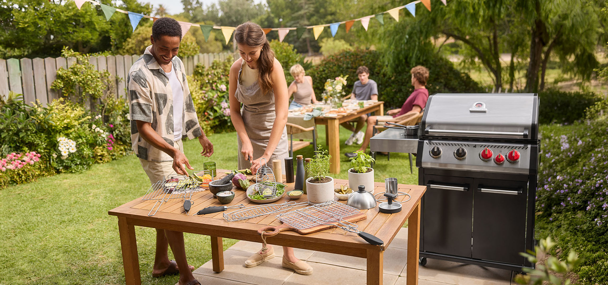Menschen bereiten Essen auf einem Grill im Garten zu, mit Gasgrill und Tisch.