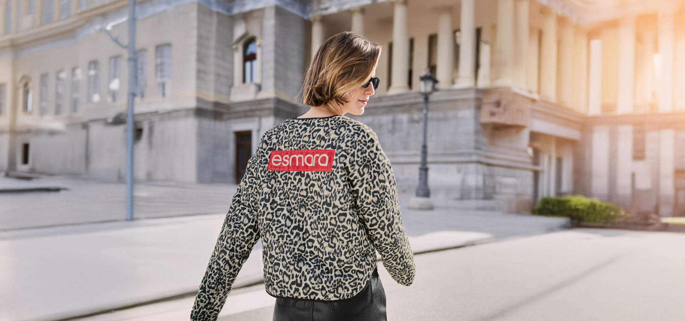 Frau in Esmara Leopardenjacke, Sonnenbrille, auf einer Stadtstraße.