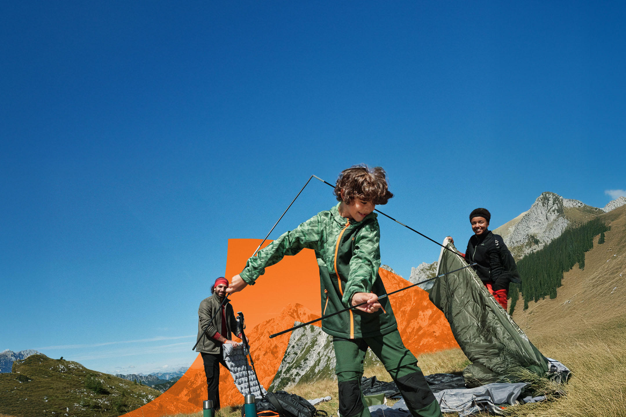 Familie baut Zelt in den Bergen auf, trägt Wanderkleidung und nutzt Campingausrüstung.