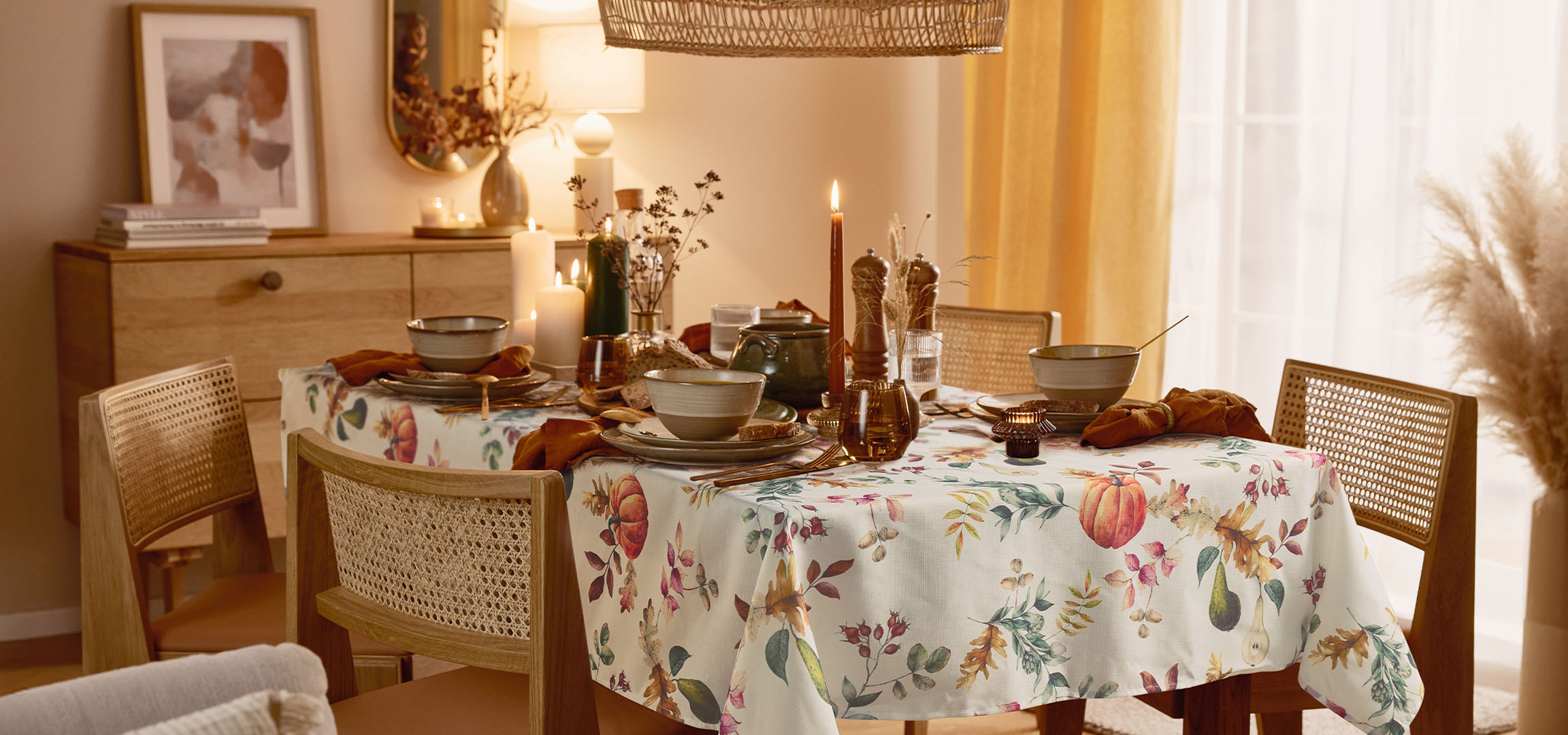 Esszimmer mit gedecktem Tisch, floraler Tischdecke und warmer Beleuchtung.