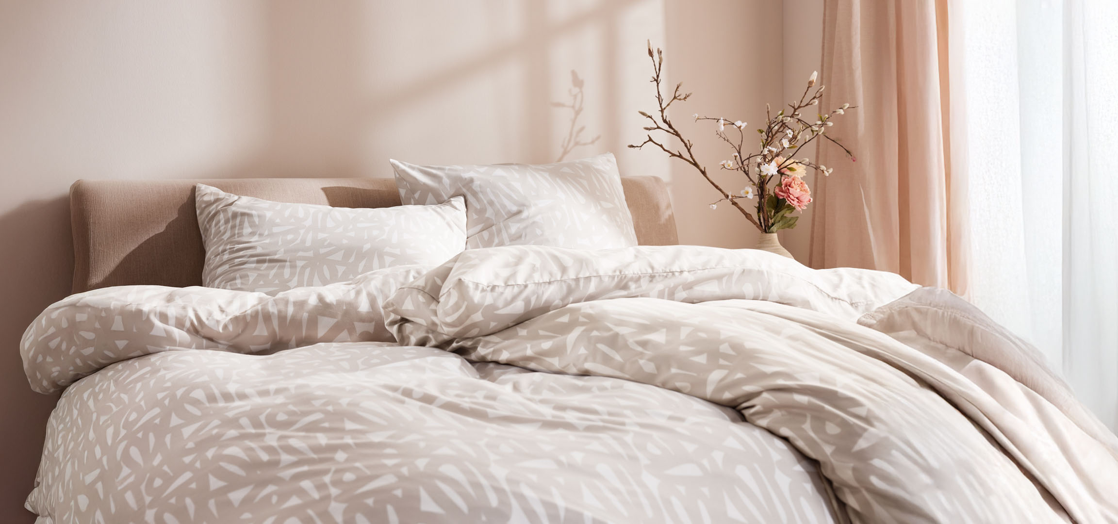 Beige Bettwäsche mit abstrakten Mustern.