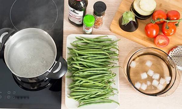 Topf, grüne Bohnen und Eiswürfel.