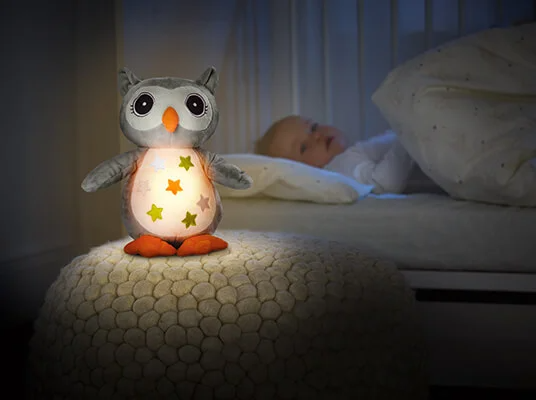 Eulen-Nachtlicht neben schlafendem Baby.