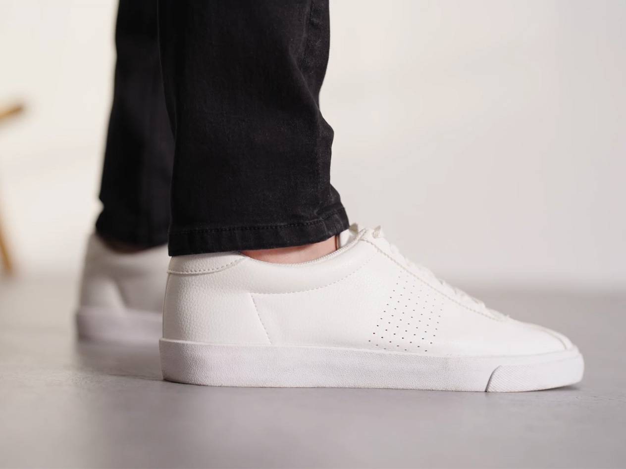 Weiße Sneaker und schwarze Jeans.