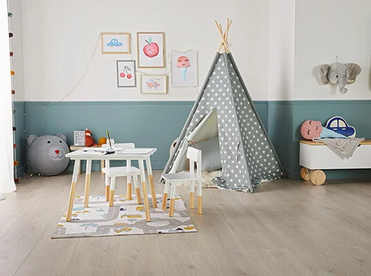Kinderzimmer mit Tipi-Zelt, Tisch und Stühlen sowie niedlichen Spielzeugen.
