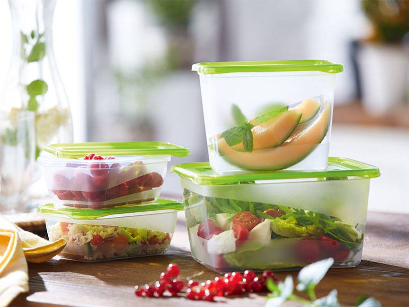 Obst-, Beeren- und Gemüsesalat in transparenten Plastikbehältern.