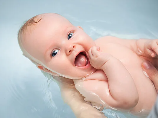 Lächendes Baby im Bad.