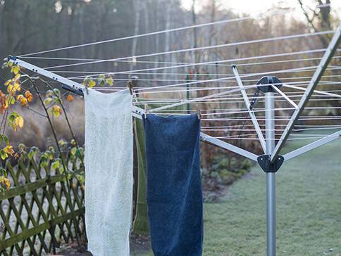 Wäscheständer mit Handtüchern und Kleidung zum Trocknen im Freien.