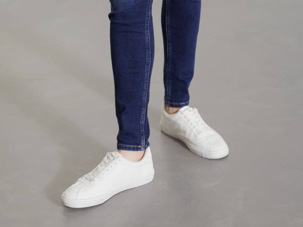 Weiße Sneaker und Jeans.
