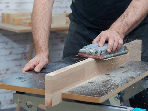 Tischler schleift Holz mit Schleifmaschine.