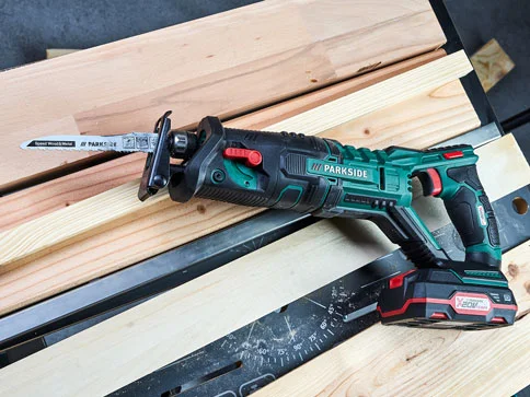 Parkside Säbelsäge und Akku auf Holz.