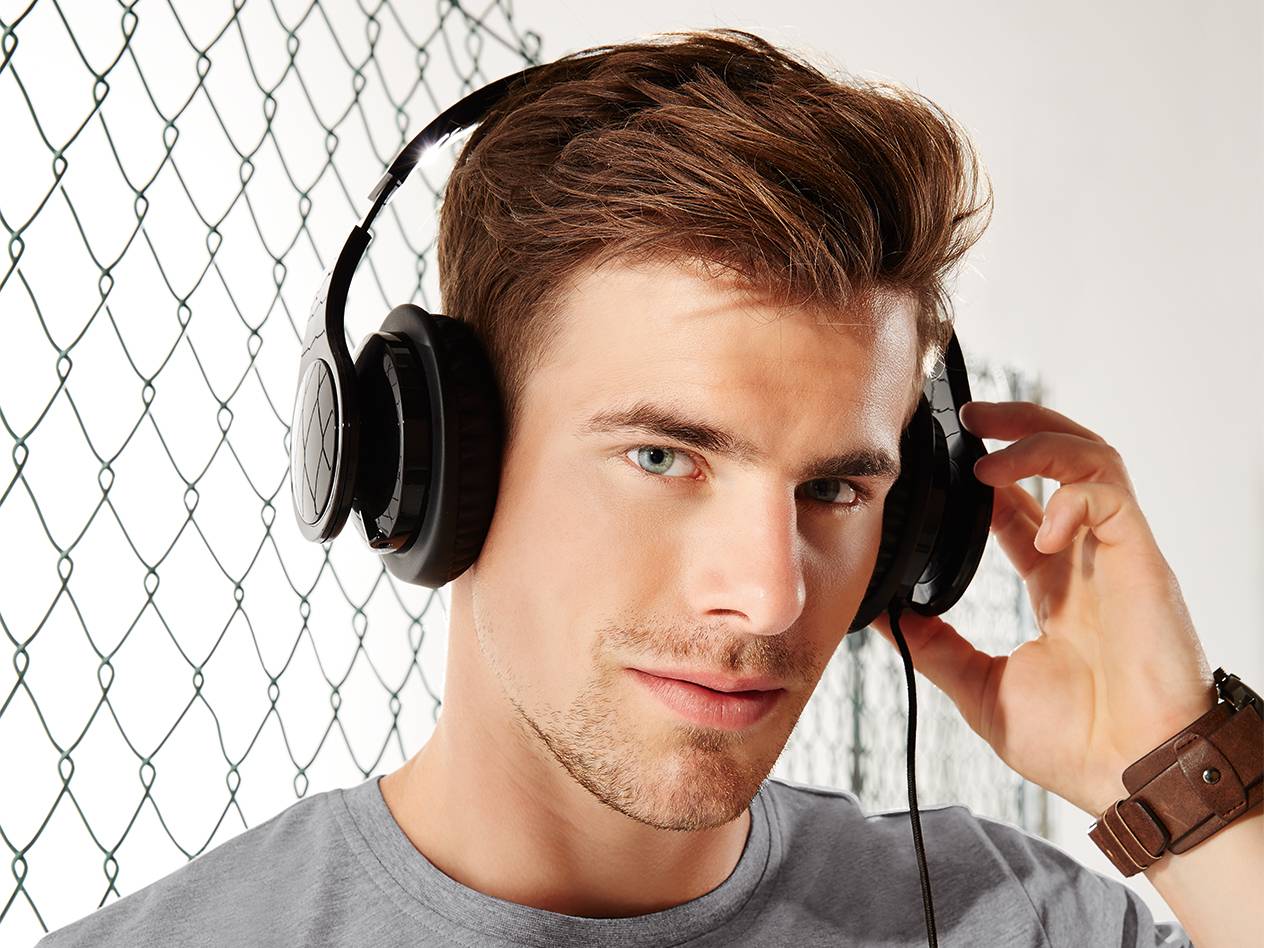 Mann hört Musik mit schwarzen Kopfhörern.