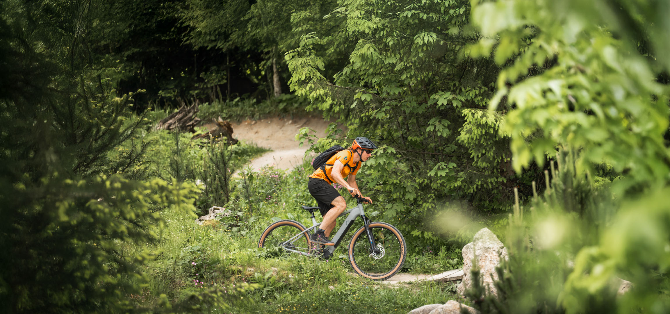 Ein Radfahrer genießt eine E-Bike-Tour auf einem Waldweg.
