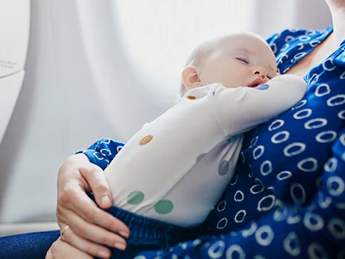 Baby schläft in Mamas Armen.