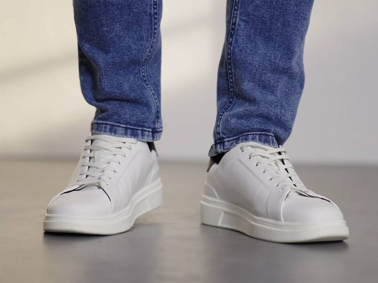 Weiße Sneaker und Jeans.