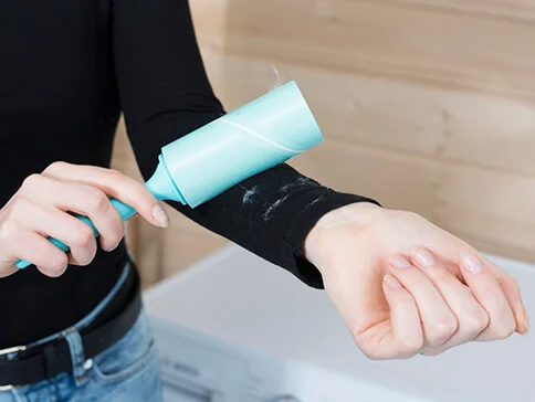 Ein Fusselroller entfernt Fusseln von Kleidung.