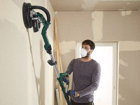 Wandglättungsgerät und Schutzkleidung im Innenbereich.