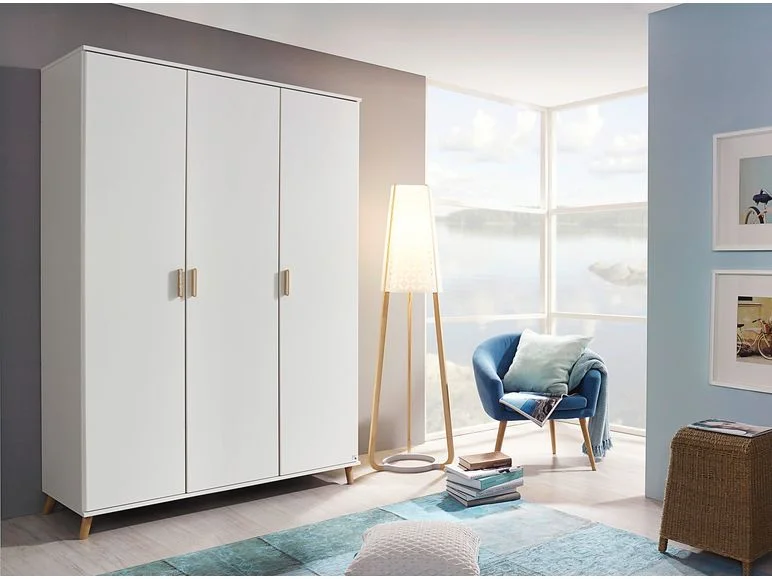 Weißer Kleiderschrank mit drei Türen und blauer Sessel.