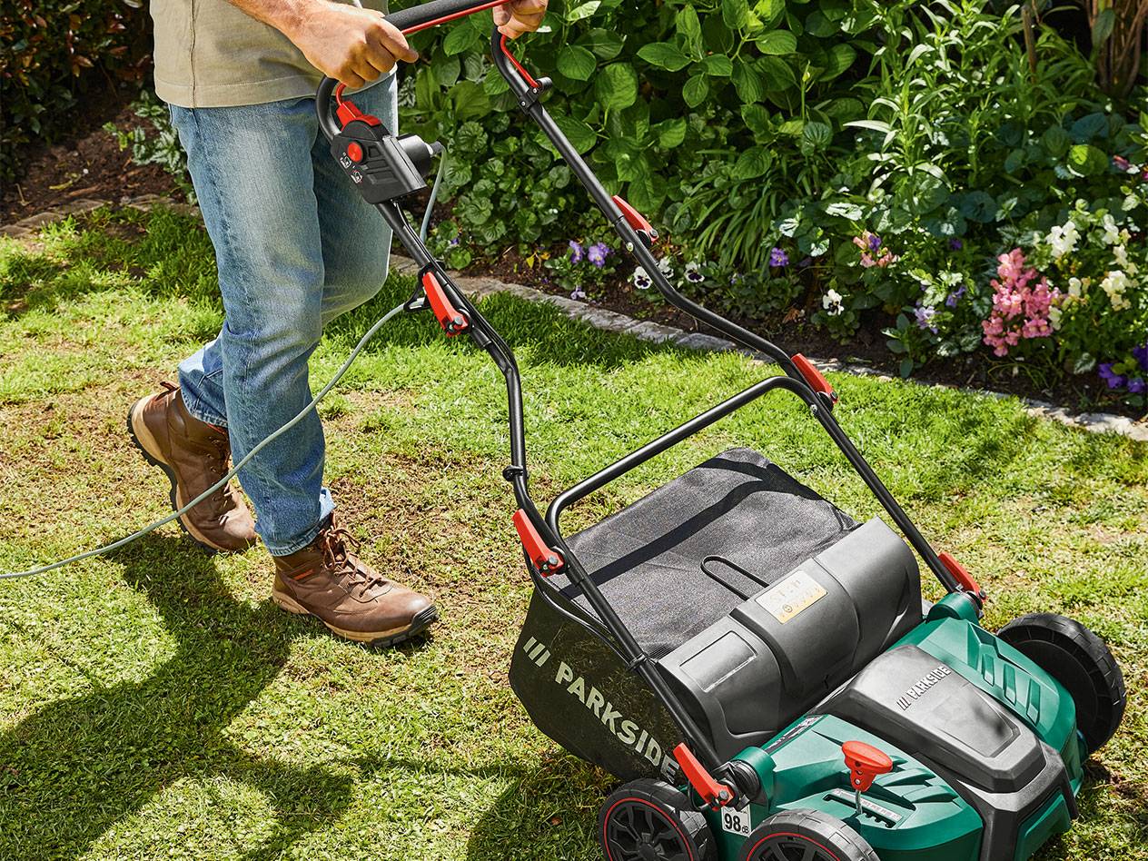 Mann benutzt Parkside Rasenlüfter und -Rechen.