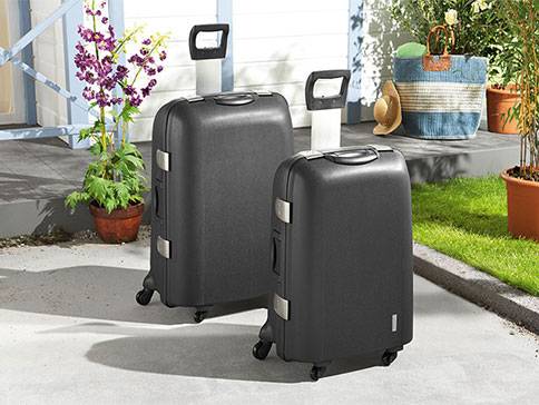 Zwei schwarze Koffer draußen.