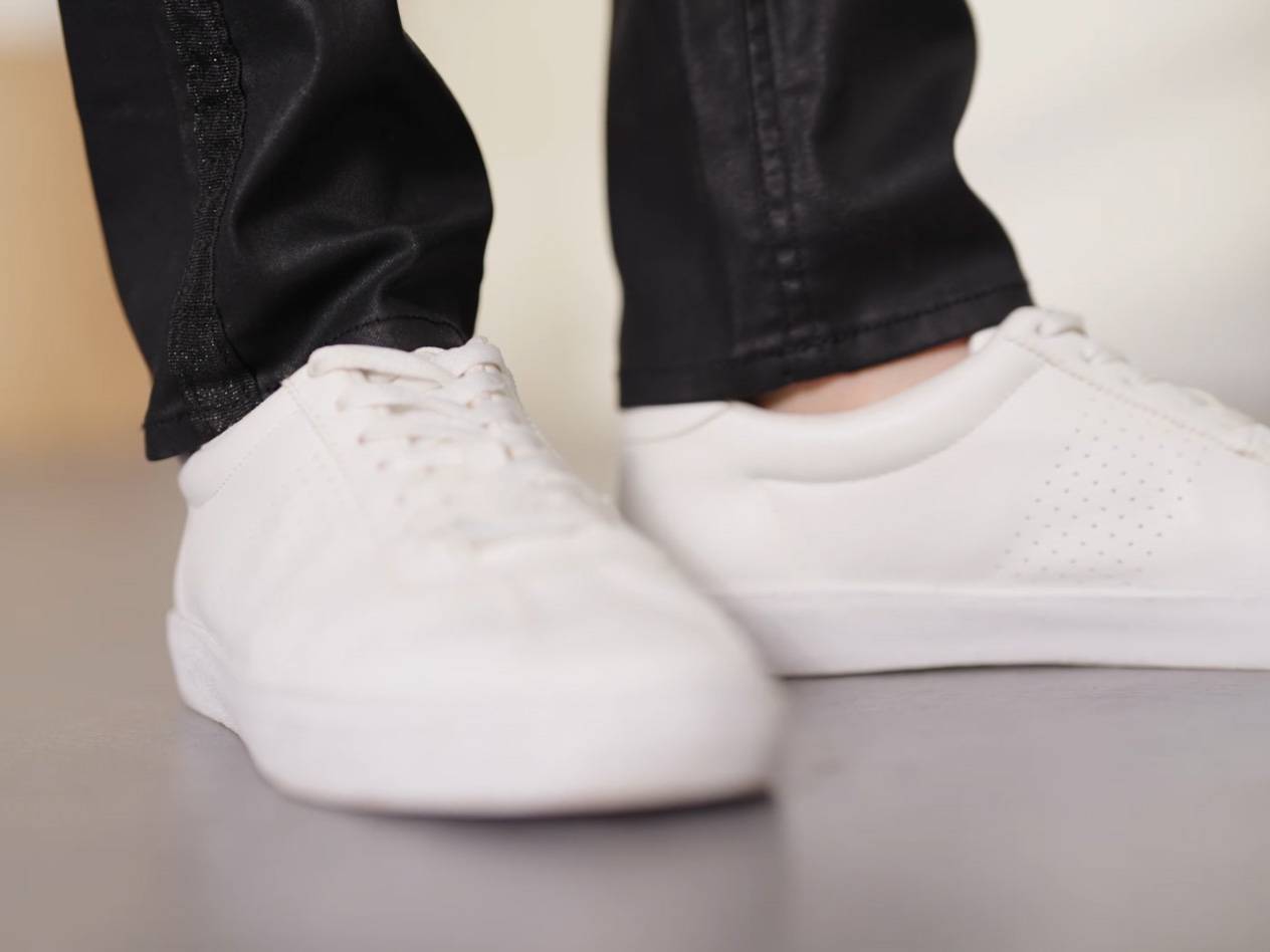 Weiße Sneaker und schwarze Jeans.