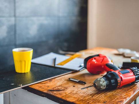 Bohrmaschine und Werkzeug auf Holztisch.