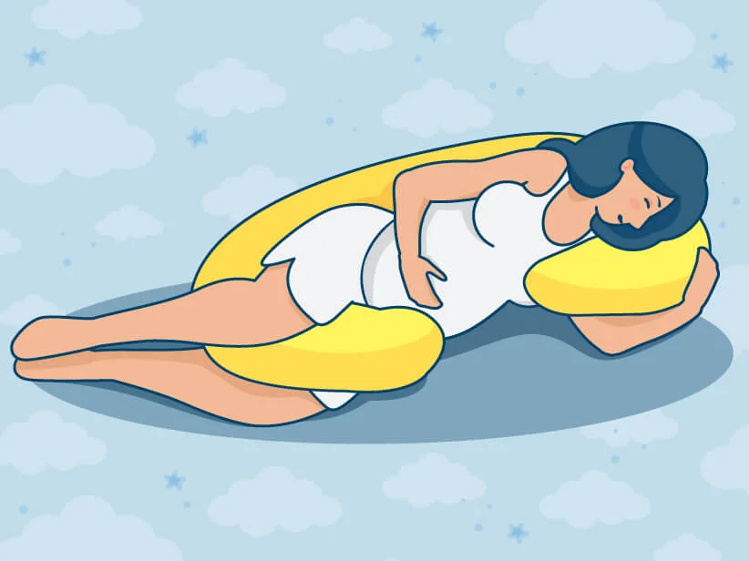 Schwangere Frau schläft auf einem gelben Schwangerschaftskissen.