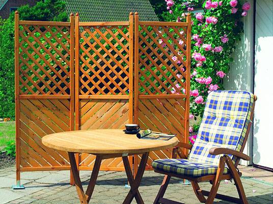 Holz-Sichtschutz, Tisch und Stuhl.