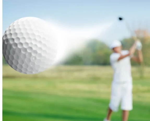 Golfball fliegt, Spieler schlägt.