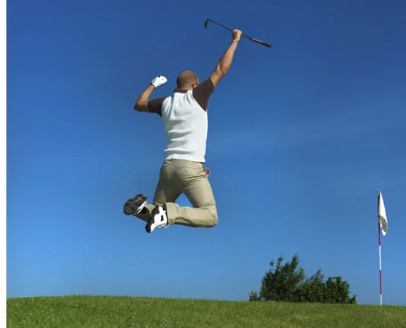 Golfspieler jubelt mit Hochsprung und Schläger.