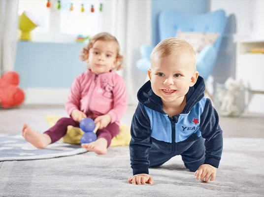 Kinderkleidung: weicher Velours-Overall und rosa Jacke für Mädchen.