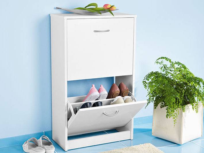 Weißer Schuhschrank mit Fächern und Schuhen.