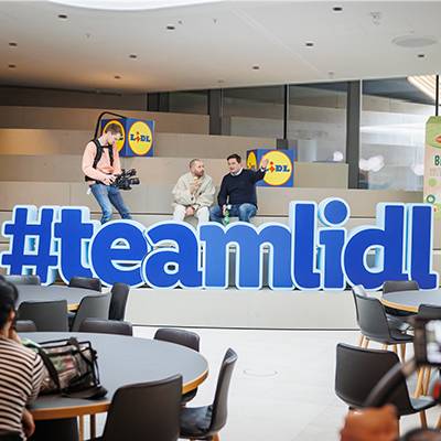 Lidl Team-Videoaufnahme, Personen mit Lidl-Logo sichtbar.