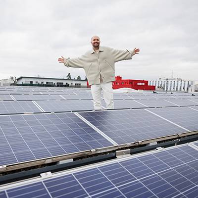Solarmodule auf dem Dach; Mann posiert.