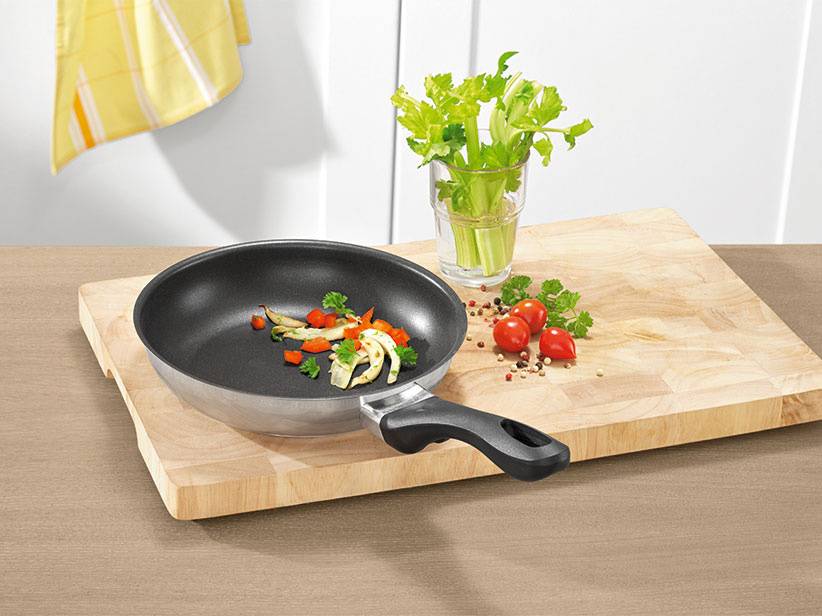 Bratpfanne und Schneidebrett: Gemüse in der Pfanne.