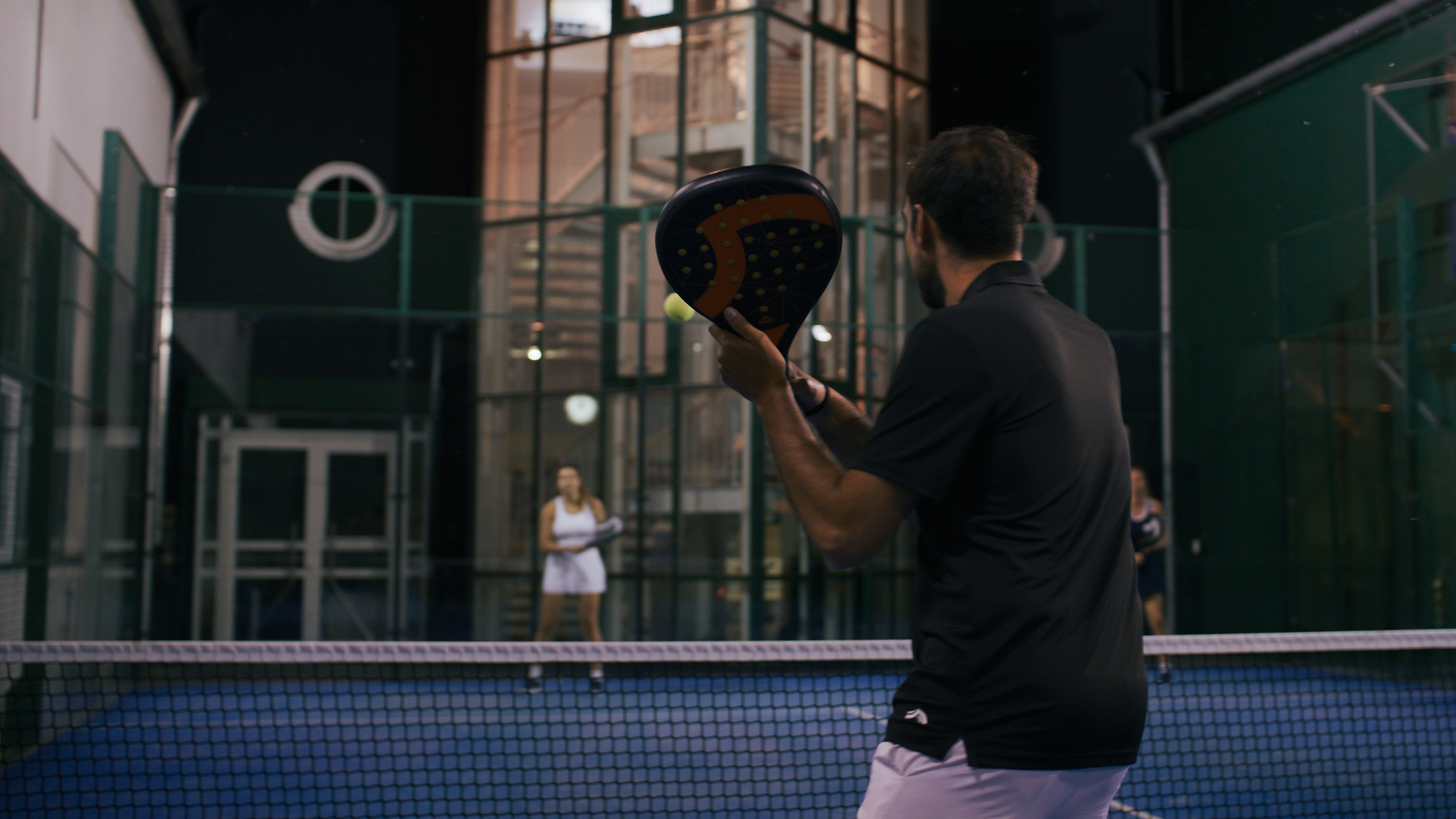 Padeltennis: Spieler mit Schläger, Nachtmatch.